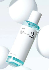 Skincare bottle with blue liquid on a light gray background