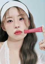 Person holding a pink lip balm with a light blue background