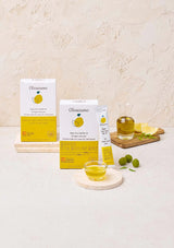 Olivazumo lemon products including boxes, jars, and a glass on a light background