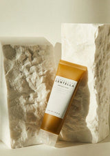 Skincare tube with 'Nurturing Centella' label on a textured stone background