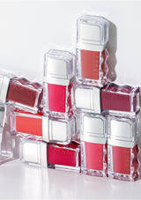 Stack of red and white cosmetic bottles with 'Gosh' branding on a light gray background