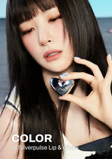 Woman holding a silver heart-shaped product with text 'Color of Silverpulse Lip & Cheek' on a blurred background