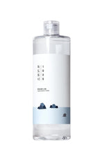 Clear bottle with a white label featuring blue mountain graphics on a white background