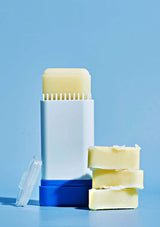 Deodorant stick and bars of soap on a blue background
