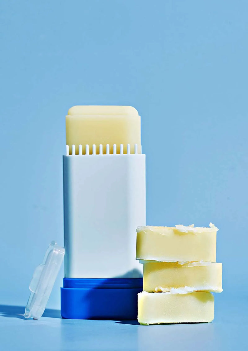 Deodorant stick and bars of soap on a blue background