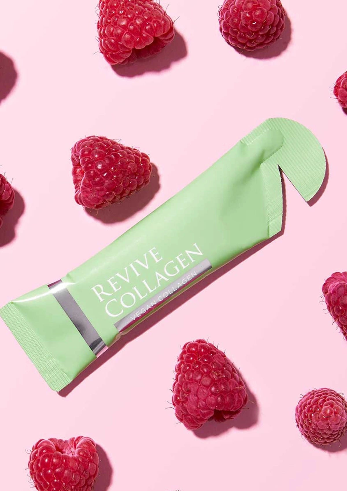 Revive Collagen package with raspberries on a pink background