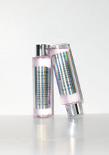 Two skincare bottles with iridescent labels on a white background