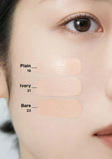 Three beige color swatches labeled 'Plain 19', 'Ivory 21', and 'Bare 23' on a person's face.