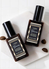 Two bottles of Groom hair essence on a white surface with a neutral background