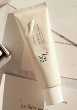 White tube of skincare product on a light wooden surface