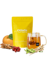 Odada tea package with a glass of tea, apples, and other elements on a white background