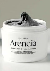 Jar of Arencia Black Tea & Yuzu Cleanser with grayish cream inside on a light gray background