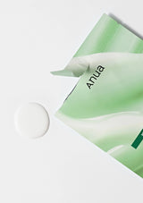 Green skincare mask with 'Anua' branding on a white background