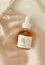 Skincare serum bottle with dropper on a soft pink background
