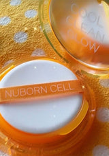 Nuborn Cell cosmetic compact with a white sponge on a yellow polka dot background