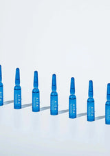 Blue AIDA ampoules arranged in a row on a light blue background