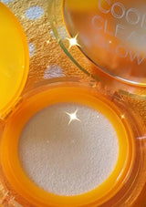 Compact powder with 'Cool Clear Glow' text on a gold and white polka dot background