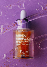 Purito Retinol Retinal 2000 NAD+ Serum in a clear dropper bottle with orange-toned liquid, set against a purple background with decorative clear gel and glitter.