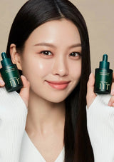 Woman holding two skincare bottles with a neutral background