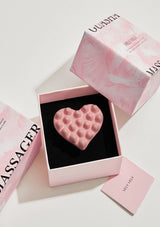 A heart-shaped pink Gua Sha massager with VELY VELY X JANS brand visible.