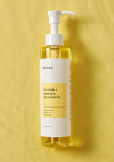 Bottle of Calendula Complete Cleansing Oil with a pump on a yellow background