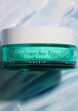 Axis-Y Cera-Heart My Type Duo Cream jar on a reflective surface