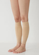Beige compression sleeves on legs against a plain background