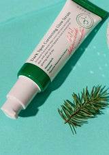 Tube of Dark Spot Correcting Glow Serum with a green leaf on a light blue background