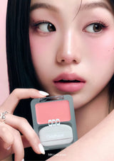 Close-up of a person holding a makeup product with a blurred background