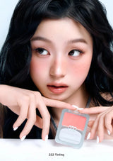 Woman holding a cosmetic product with a close-up of the product on a white background