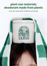 Person wearing a green and white checkered towel with a container labeled 'LEAFIN' on a white background.
