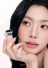 Close-up of a person holding a pink lip product with a soft focus background