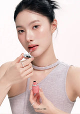 Woman applying pink lipstick with a white background