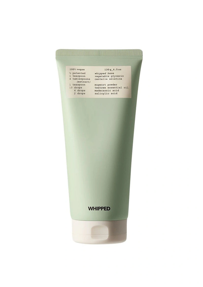 Green tube of whipped product with a label on a white background