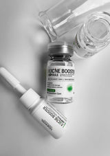 Skincare products including a bottle and ampoule on a light gray background