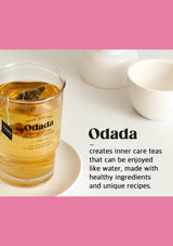 Glass of Odada tea with a tea bag on a white surface, featuring the Odada brand.