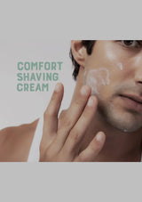 Man applying shaving cream to his face with 'Comfort Shaving Cream' text.