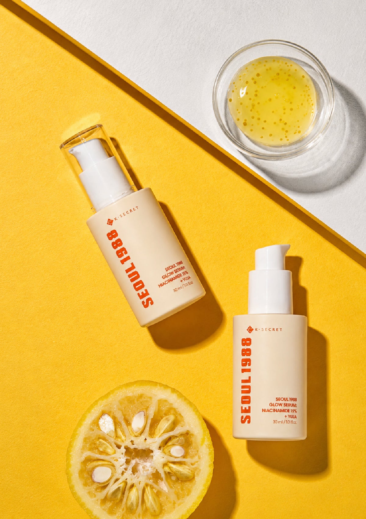 Two skincare bottles with a lemon on a yellow and white background