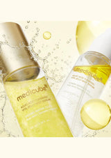 Two skincare products with a yellow liquid on a light background