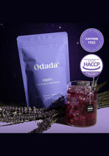 Odada product packaging with a glass of red drink and lavender on a dark background