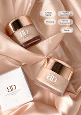 Two skincare jars with rose gold lids on a soft pink fabric background, featuring text labels on the jars.