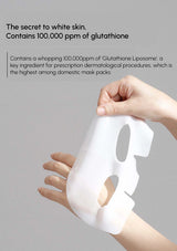 Hand holding a white sheet mask with text about glutathione content on a gray background