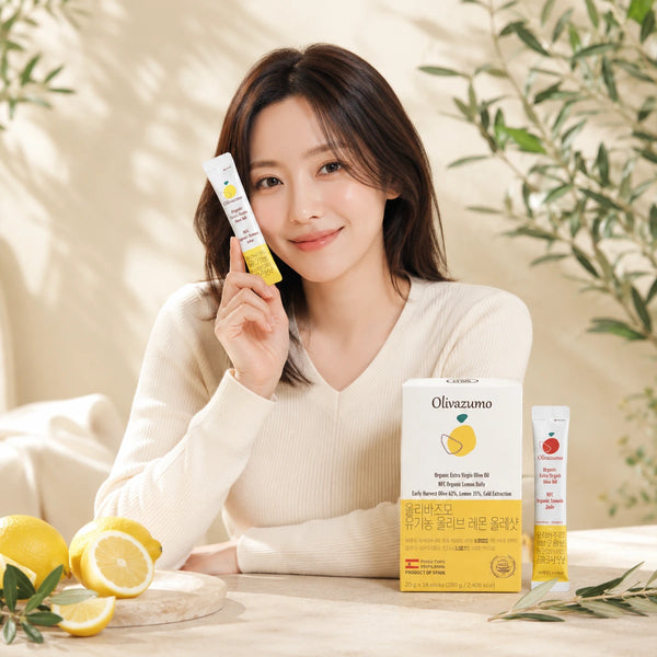 Woman holding an OLIVAZUMO lemon sachet beside the box and fresh lemons