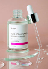 Rose Galactomyces Synergy Serum with dropper on a pink background
