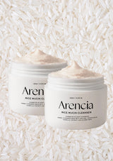 Two jars of Arencia Rice Mucin Cleanser on a background of white rice grains.