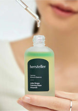 Hersteller ampoule bottle held by a person with a blurred background
