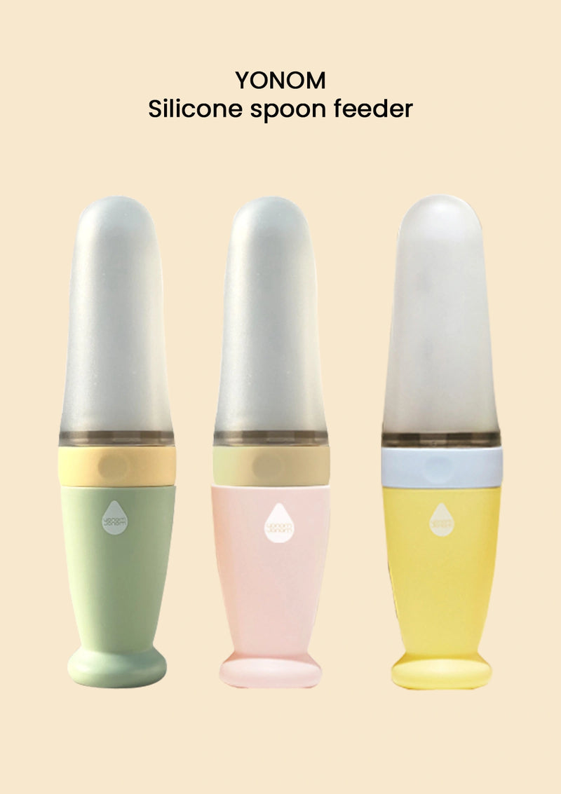Three silicone spoon feeders in different colors on a beige background with 'YONOM' branding.