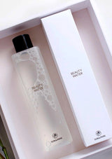 Bottle of 'Beauty Water' with packaging on a light pink background