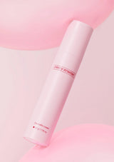 Pink skincare tube on a pink and gray gradient background