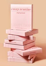 Stack of pink 'every routine' boxes on a beige background